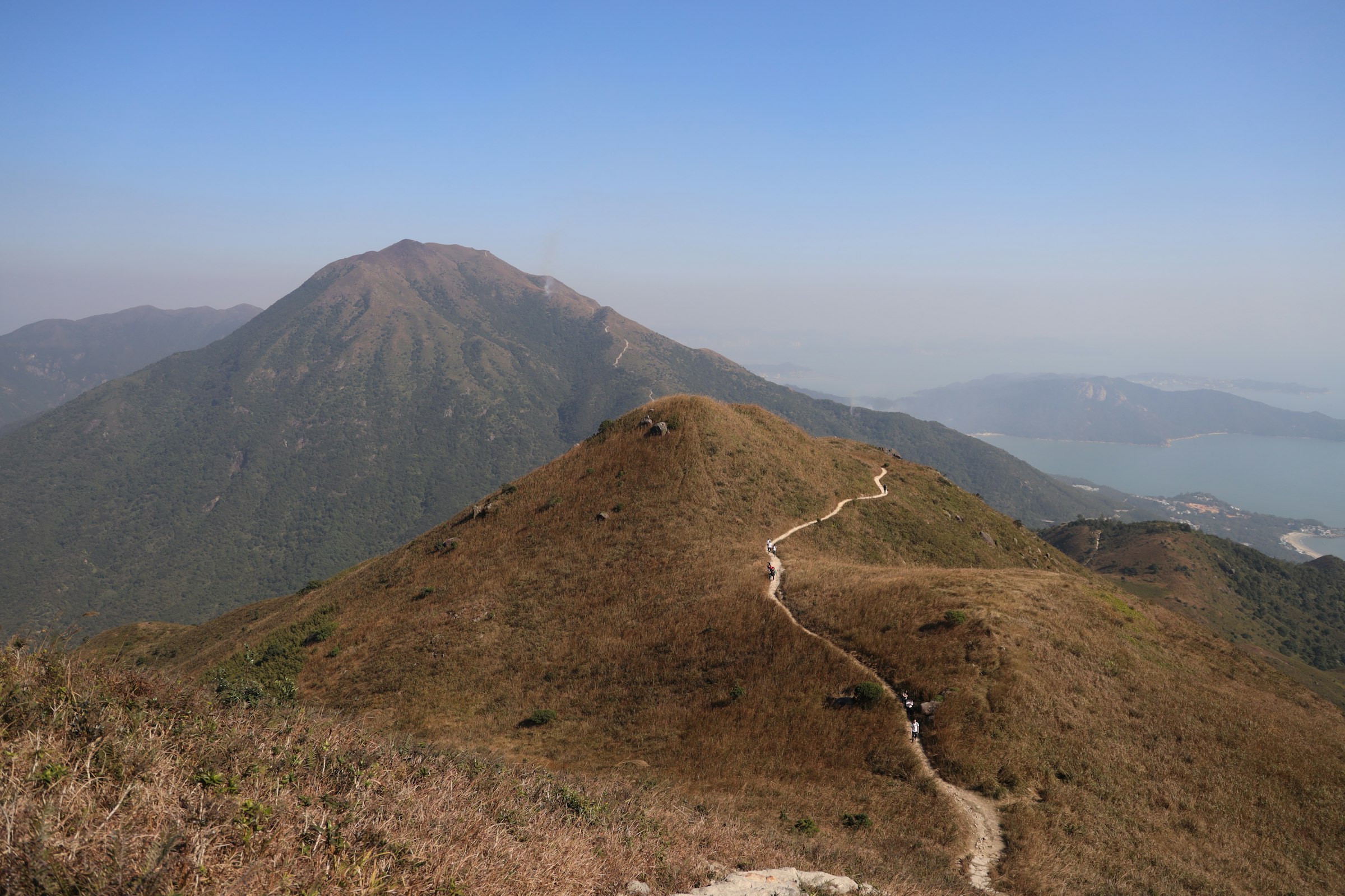 Trail runners crest a Hong Kong ridge at sunrise